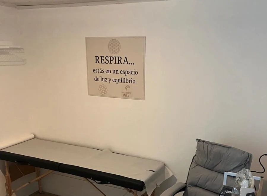 Sala de consulta de Resurgir Vital con camilla y el rótulo Respira, estás en un espacio de luz y equilibrio